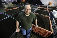 a man standing in front of piles of dirt