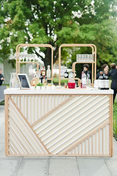 an outdoor bar with bottles and glasses on it