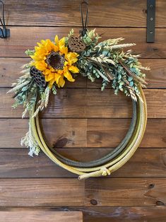 a sunflower wreath hanging on a wooden wall