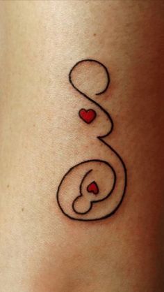 a small tattoo on the side of a woman's stomach with two hearts in it