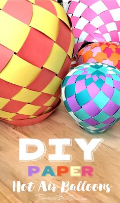 several colorful hot air balloons sitting on top of a wooden table with text overlay that reads diy paper hot air balloons