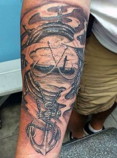 a man's arm with an anchor and ship tattoo on the left side of his arm