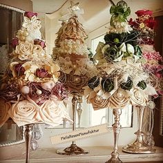 three vases filled with different types of flowers on top of a table in front of a mirror