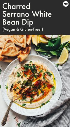 a white plate topped with hummus and pita bread