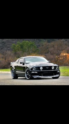 a black mustang is parked on the street