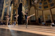 several dancers are performing on the floor in front of people sitting and standing around them