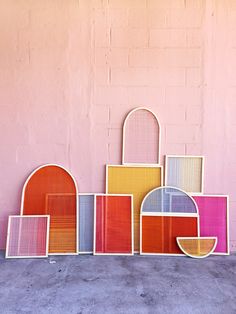 a group of different colored frames sitting next to each other on top of a cement floor