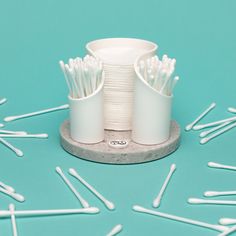 several white toothbrushes sitting on top of a cup holder with pins all over it