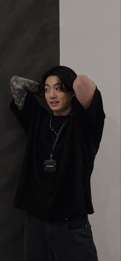 a young man is posing with his arm behind his head
