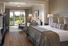 a bedroom with a large bed and wooden flooring next to a sliding glass door