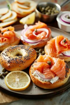 bagels with salmon, capers and onions on them are arranged on a plate