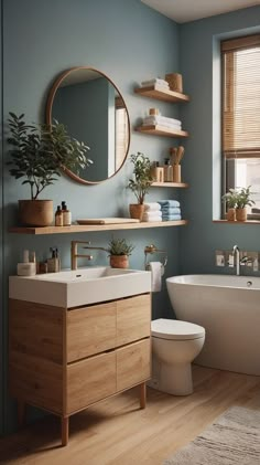 a bath room with a toilet a sink and a tub next to a window in it