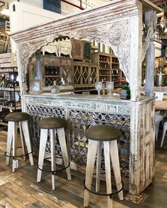 an old fashioned bar with stools in a store