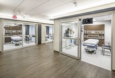 an empty hospital room with medical equipment in the back and on the front, as well as tables and chairs