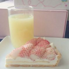 a piece of cake on a plate next to a glass of milk and orange juice