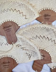 three wooden paddles with lace on them sitting on top of a white table cloth