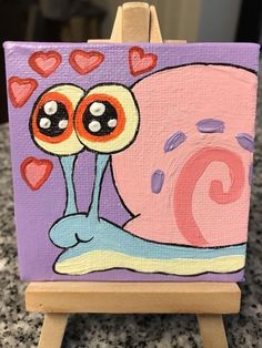 a painting of a snail with hearts on it's head and eyes painted on an easel