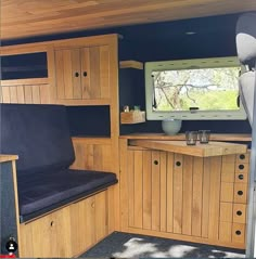 the inside of a camper with wood paneling and black leather seat cushiones