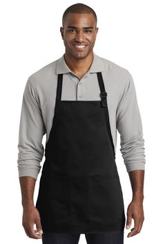 a man wearing an apron and smiling at the camera with his hands in his pockets