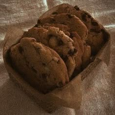 chocolate chip cookies in a cardboard box on a white sheeted tablecloth, ready to be eaten