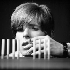 a person leaning over a table with toothpicks on it's face in front of them