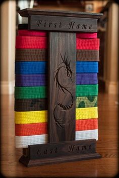 a wooden sign that says first name and is surrounded by colorful belts on a table