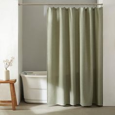 a white tub sitting next to a shower curtain