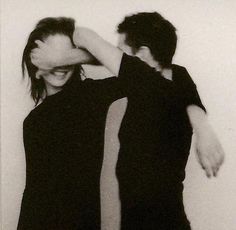 two people standing next to each other with their arms around one another's head