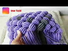 someone is holding some purple yarn on top of a white pillow with the words ma yaad