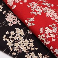 two red and black fabrics with white flowers on them, one in the foreground