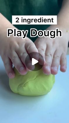 a child is playing with play dough on the table and has their hands touching it