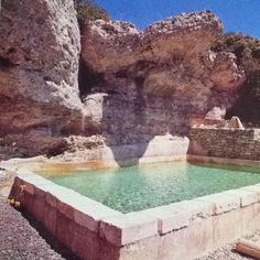 there is a small pool in the middle of some rocks