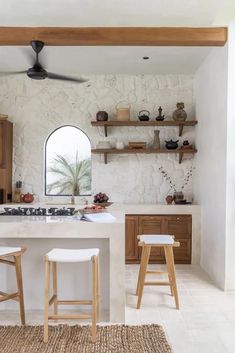 a kitchen with two stools next to an island