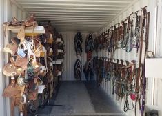 the inside of a shipping container filled with lots of different types of purses and belts