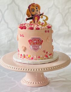 a pink birthday cake with a cartoon dog on top