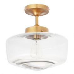 a light fixture with a clear glass bowl on the top and a gold plated finish