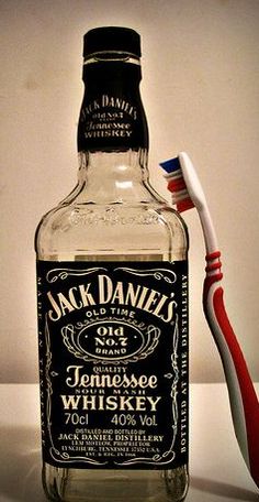 a toothbrush sitting next to a bottle of whiskey