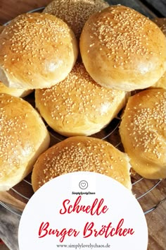 small hamburger buns with sesame seeds in a glass bowl on a wooden table top