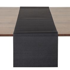 a black table runner on top of a wooden table