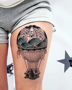 a woman's thigh with a hot air balloon tattoo on it