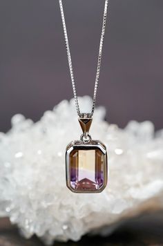 "Experience the brilliance of AAA-grade, genuine, natural emerald-cut Ametrine stone, elegantly set in a premium solid 925 sterling silver bezel setting. This necklace comes complete with an 18-inch (45cm) sterling silver box chain. The Ametrine radiates exceptional shine from every angle. Dimension: Pendant: Approx. width 10.8mm | height: 20.5mm (Including Bail) Sterling Silver Box Chain Necklace: Approx. 18\" (45cm) ❤ Healing Power of Ametrine Ametrine, a blend of amethyst and citrine, is believed to offer balance, clarity, and spiritual growth while reducing stress and enhancing creativity. Some also associate it with attracting wealth, though these claims lack scientific backing and should complement, not replace, medical care. ❤Packaging Each piece is packaged with love and great care Amethyst And Citrine, Attracting Wealth, Cross Earrings Studs, Box Chain Necklace, Necklace Purple, Jewelry Accessories Ideas, Tourmaline Jewelry, Custom Ring, Classy Jewelry