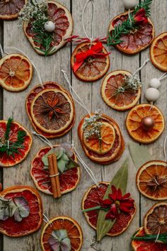 an assortment of orange slices and cinnamons on a wooden table with christmas decorations around them