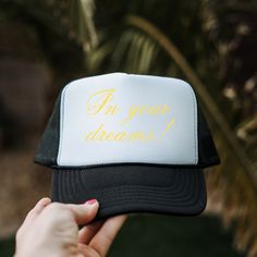 a person holding up a trucker hat with the words i'm your dreams written on it