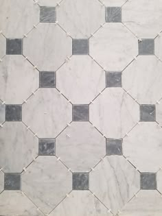 a white marble tile with black and grey squares