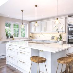 a kitchen with two stools and an island in front of the stove top oven