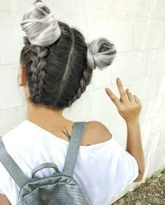 a woman with grey hair is holding her hand up in the air while wearing a backpack