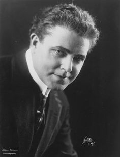 an old black and white photo of a man in a suit with his eyes closed