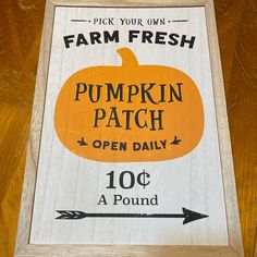 a sign advertising pumpkin patch on the side of a wooden table with an arrow pointing to it