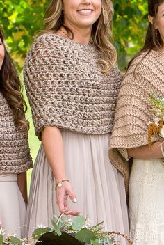 three bridesmaids pose for the camera with their bouquets in front of them