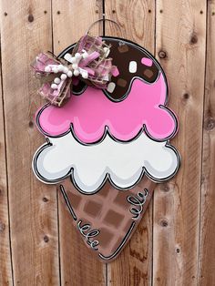 a pink ice cream sundae hanging on a wooden fence